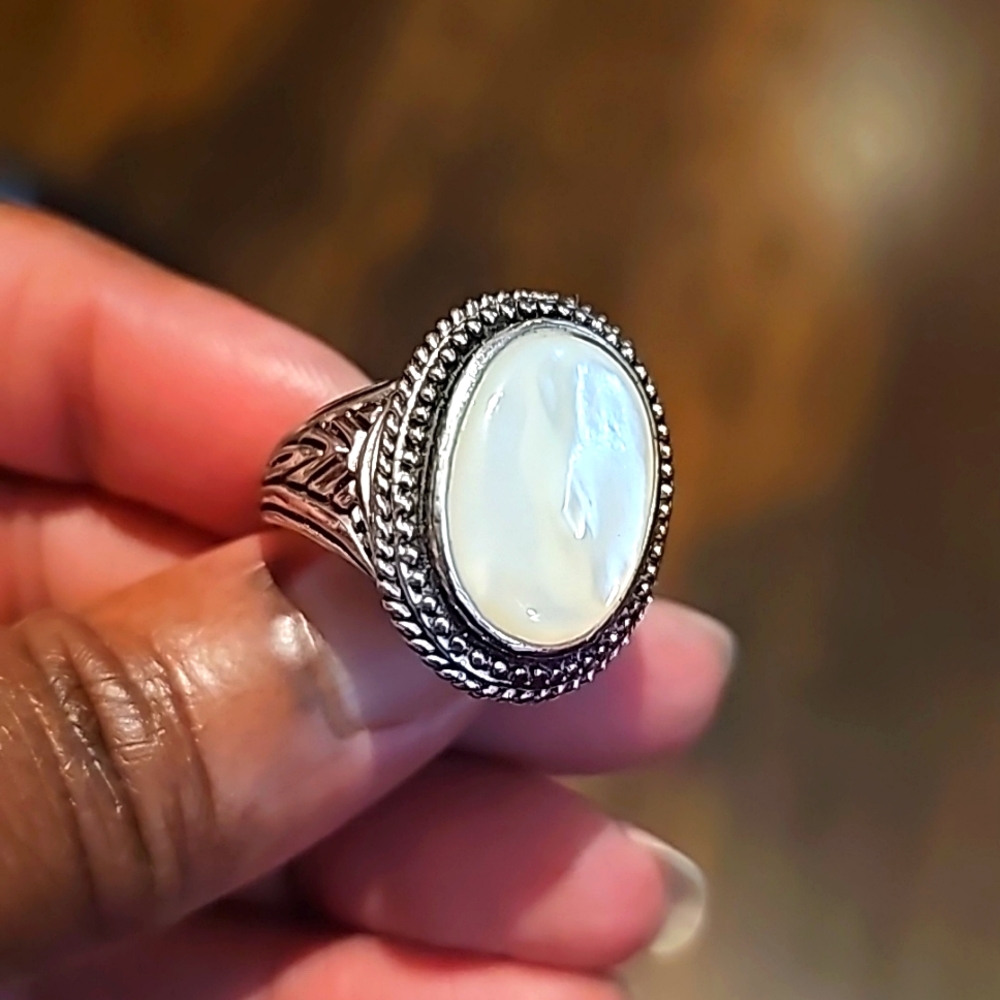 Beautiful and detailed silver metal ring. Has simulated opal stone in the center